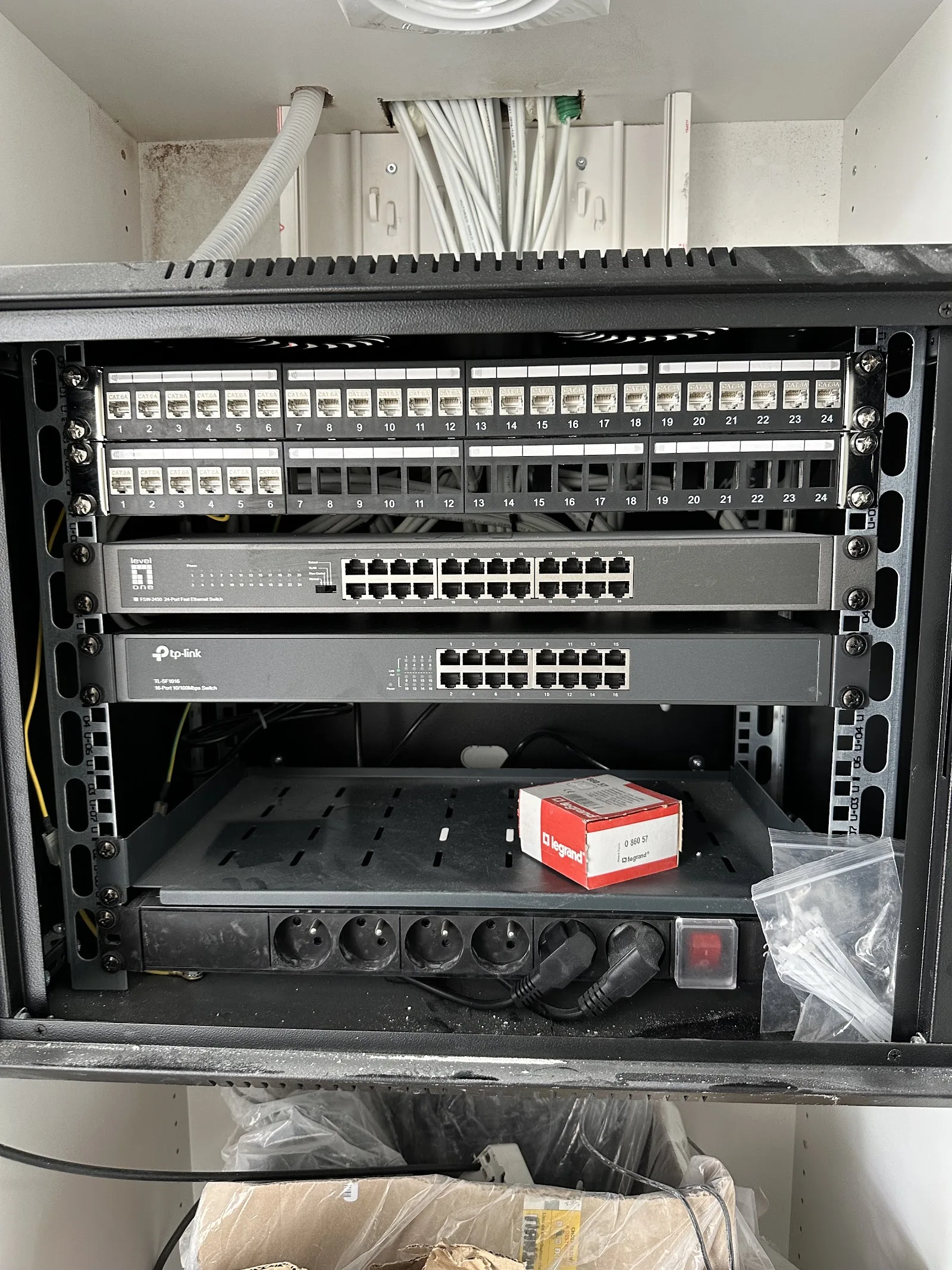 Baie de brassage avec panneaux Cat 6A numérotés et switchs.