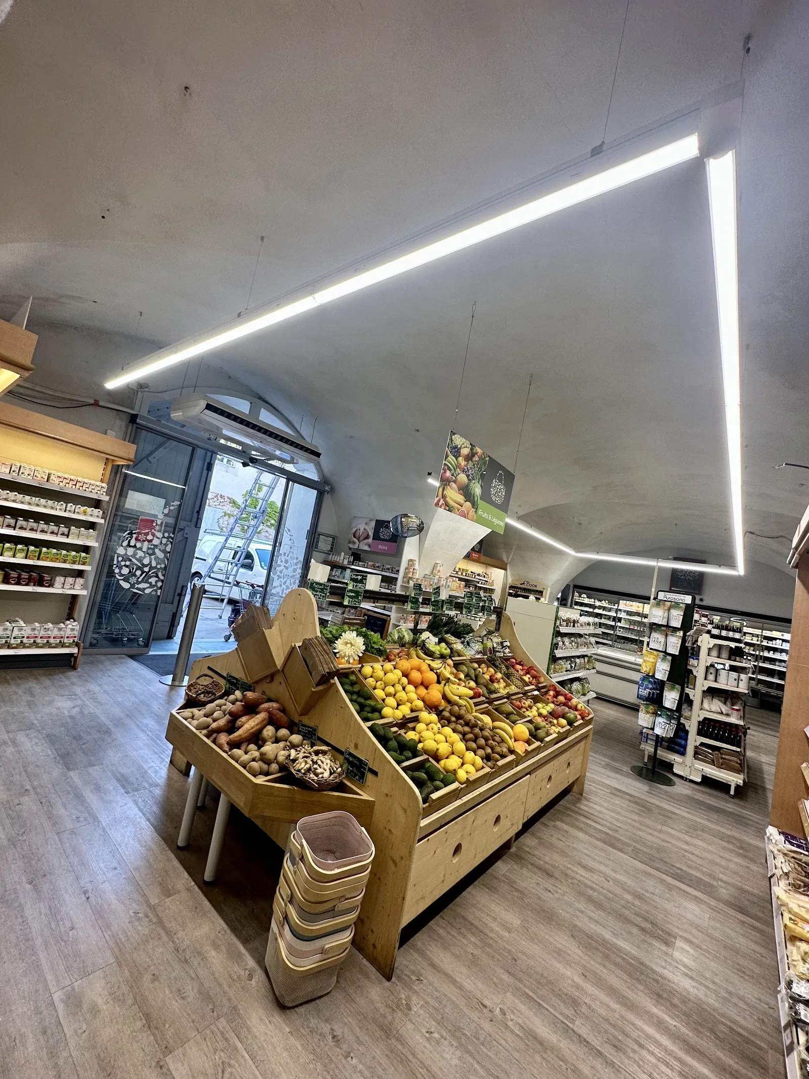 Épicerie éclairée par une ligne lumineuse continue au plafond.